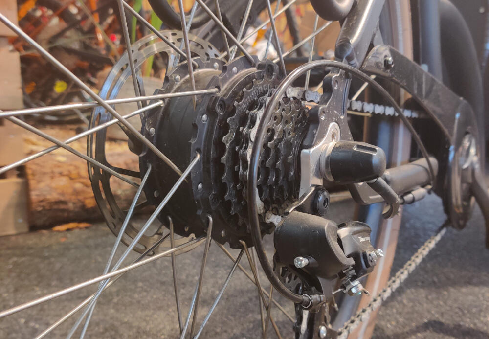 Billedet viser en motor i narv på en elladcykel. Ladcykler med baghjulsmotor er et meget populært valg på grund af prisen og hjælpen motoren yder.